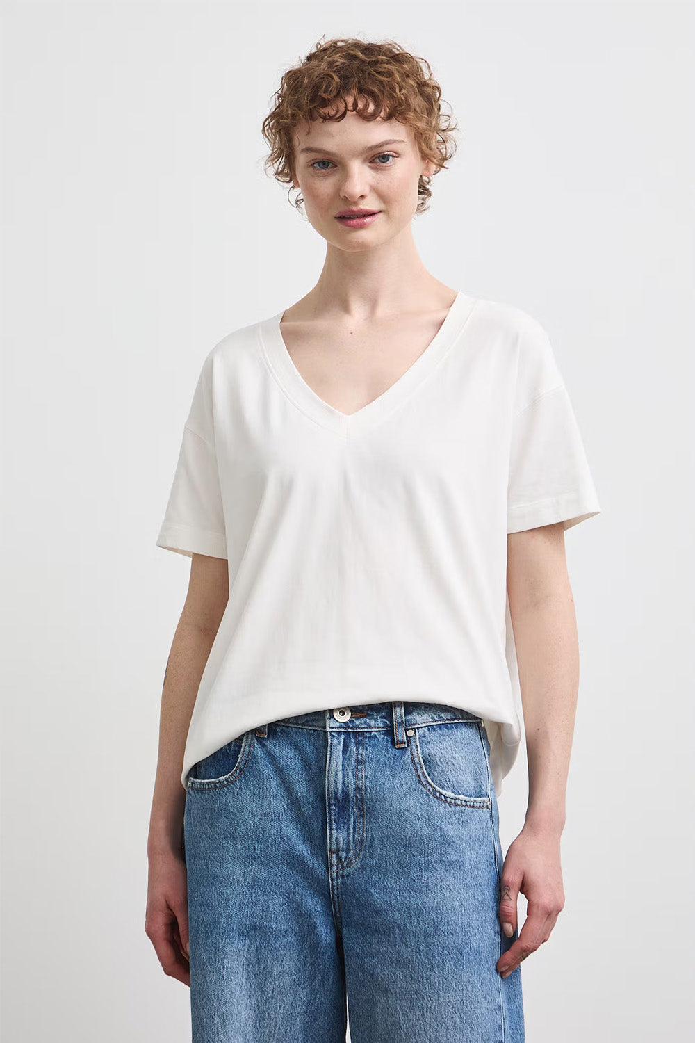 Γυναικεία Off White μπλούζα V-neck με κοντό μανίκι και πολύχρωμο floral print στην πλάτη.