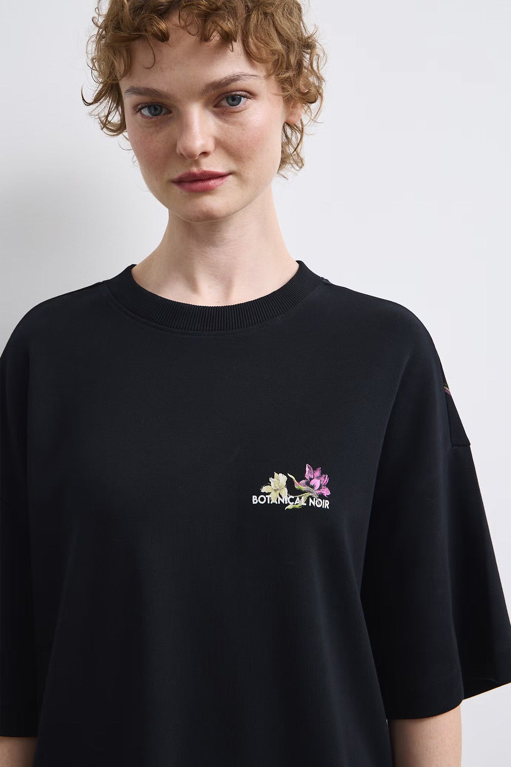 Γυναικεία μαύρη oversized βαμβακερή μπλούζα Botanical Noir με μεγάλο floral print στην πλάτη
