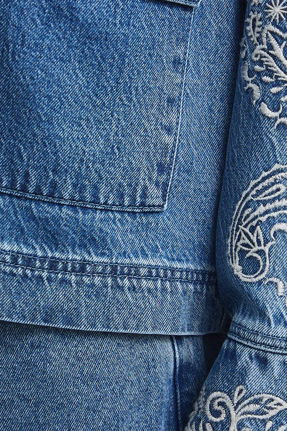 Γυναικείο μπλε denim jacket με εκρού κεντήματα στα μανίκια και μπροστινές τσέπες