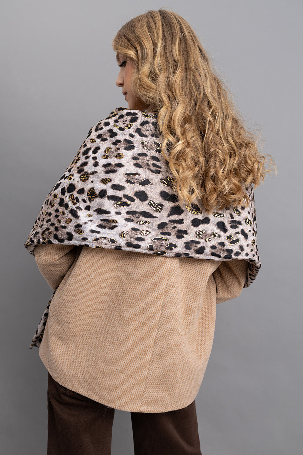 Γυναικείο φουλάρι animal print με λεοπάρ μοτίβο και χρυσές λεπτομέρειες, φορεμένο στους ώμους πάνω από μπεζ παλτό.