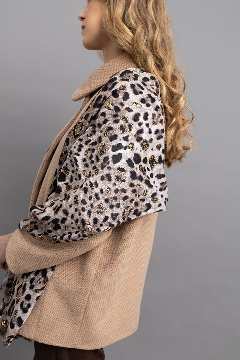 Γυναικείο φουλάρι animal print με λεοπάρ μοτίβο και χρυσές λεπτομέρειες, φορεμένο στους ώμους πάνω από μπεζ παλτό.