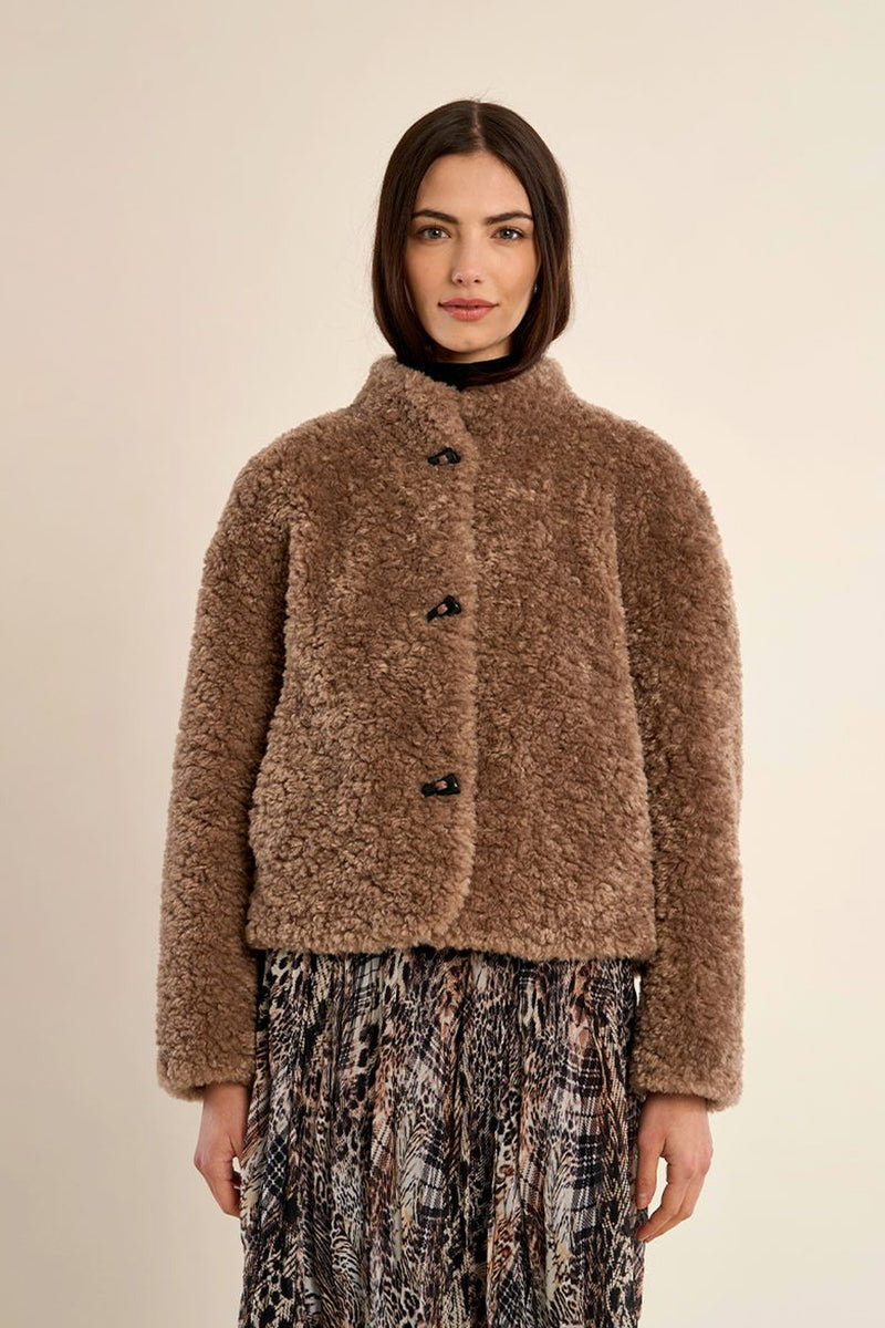 Γυναικείο κοντό teddy jacket σε καφέ απόχρωση με ψηλό γιακά, μακριά μανίκια και πλαϊνές τσέπες.