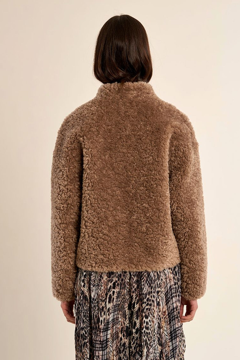 Γυναικείο κοντό teddy jacket σε καφέ απόχρωση με ψηλό γιακά, μακριά μανίκια και πλαϊνές τσέπες.