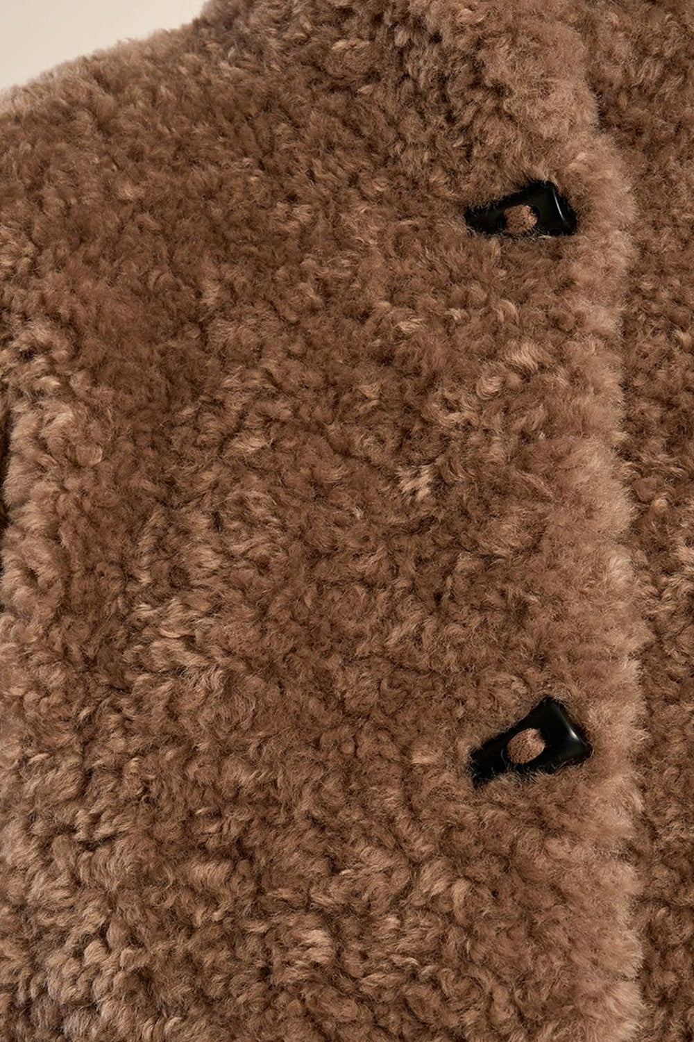 Γυναικείο κοντό teddy jacket σε καφέ απόχρωση με ψηλό γιακά, μακριά μανίκια και πλαϊνές τσέπες.