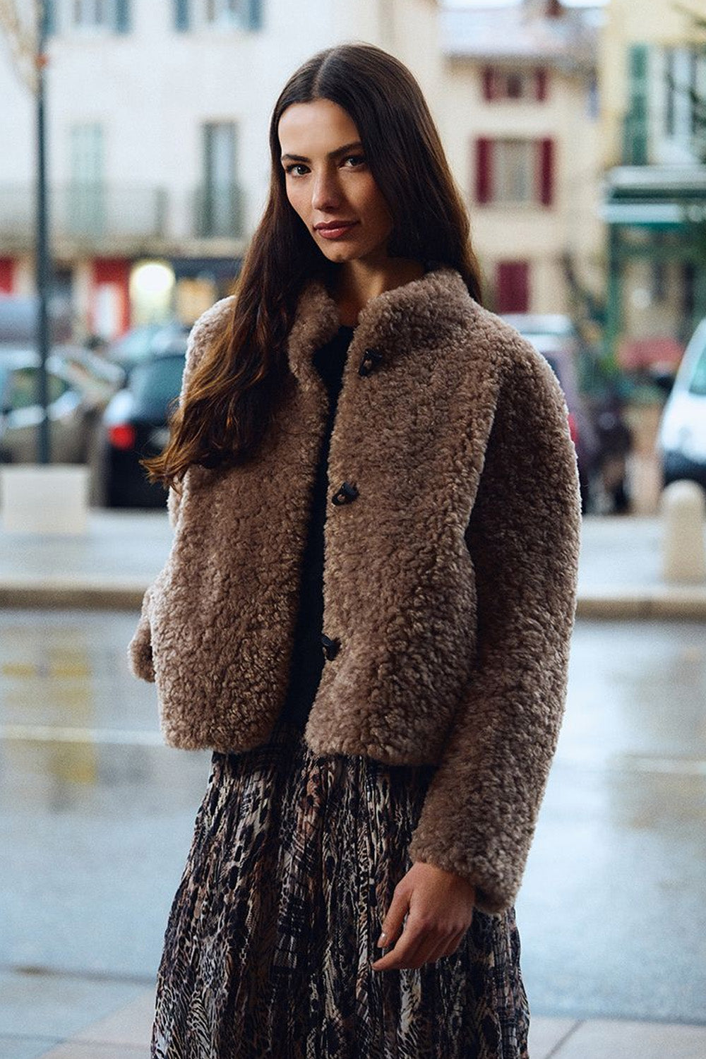 Γυναικείο κοντό teddy jacket σε καφέ απόχρωση με ψηλό γιακά, μακριά μανίκια και πλαϊνές τσέπες.