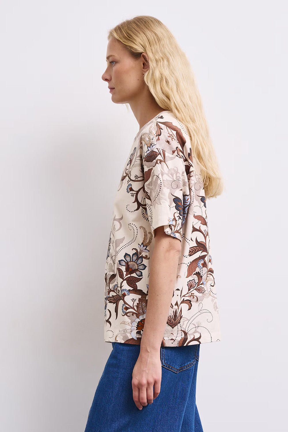 Γυναικείο εκρού T-shirt με floral print σε καφέ και γαλάζιους τόνους, άνετη γραμμή και κοντά μανίκια, πίσω όψη.