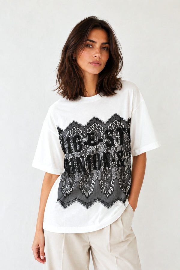 Γυναικείο λευκό oversized T-shirt με μαύρη δαντέλα και τύπωμα στο μπροστινό μέρος.
