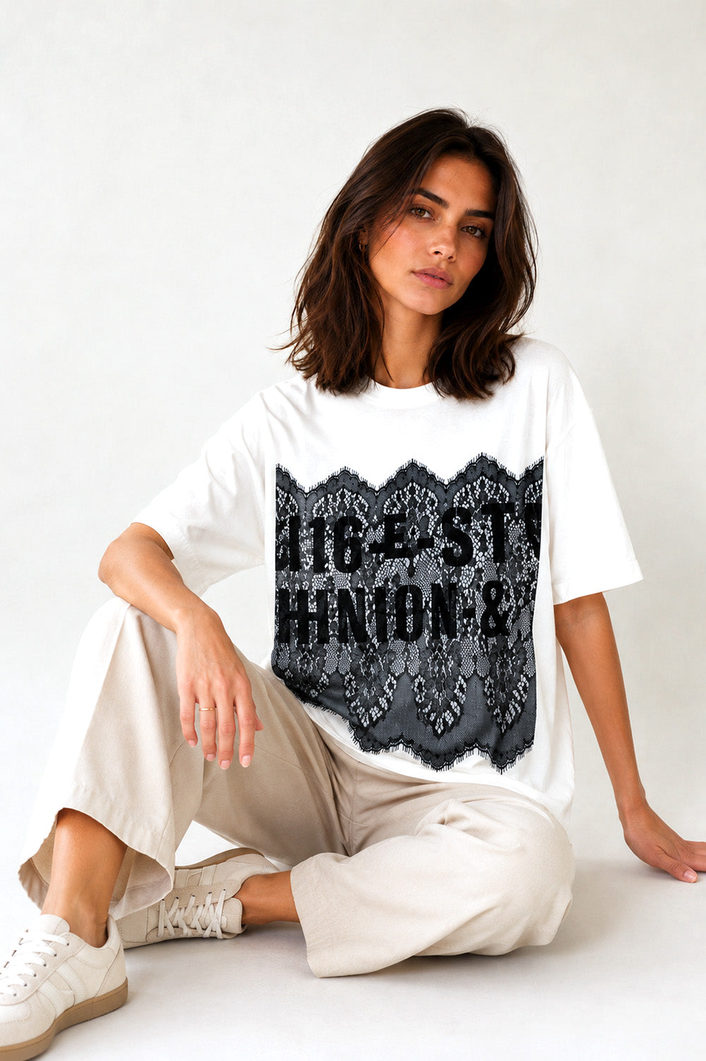 Γυναικείο λευκό oversized T-shirt με μαύρη δαντέλα και τύπωμα στο μπροστινό μέρος.