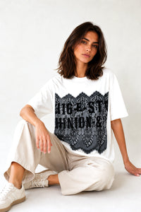 Γυναικείο λευκό oversized T-shirt με μαύρη δαντέλα και τύπωμα στο μπροστινό μέρος.