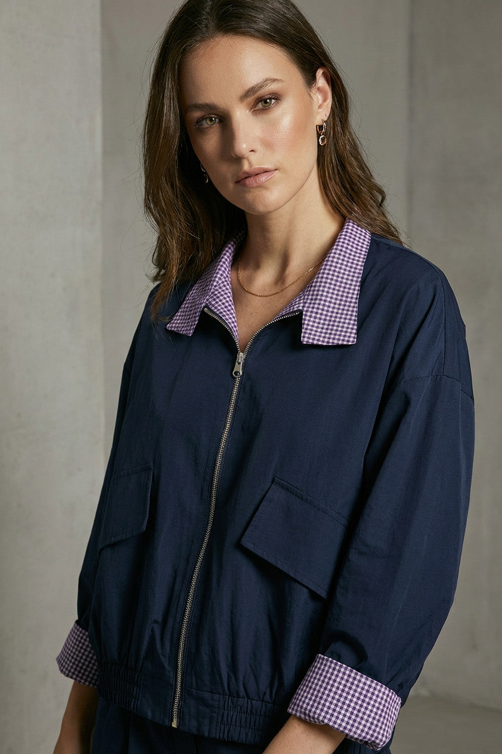 Γυναικείο jacket διπλής όψης καρό μωβ-λευκό με navy λεπτομέρειες και φερμουάρ μπροστά.