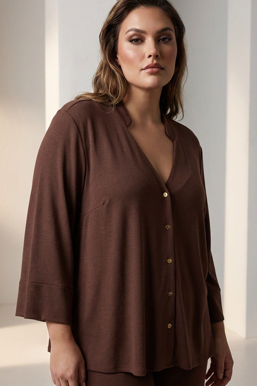 Καφέ γυναικείο πουκάμισο με V λαιμόκοψη και κουμπιά σε άνετη γραμμή, φορεμένο από μοντέλο.