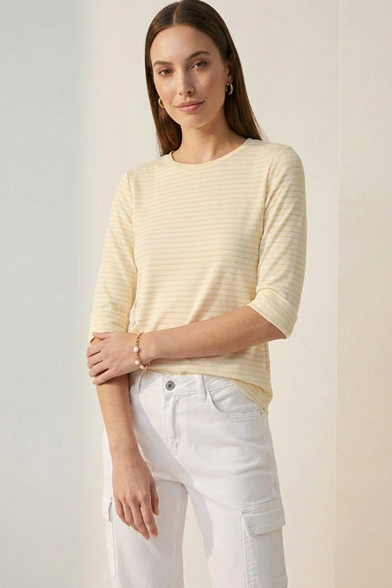 Κίτρινη ριγέ μπλούζα με 3/4 μανίκι και στρογγυλή λαιμόκοψη φορεμένη με λευκό παντελόνι