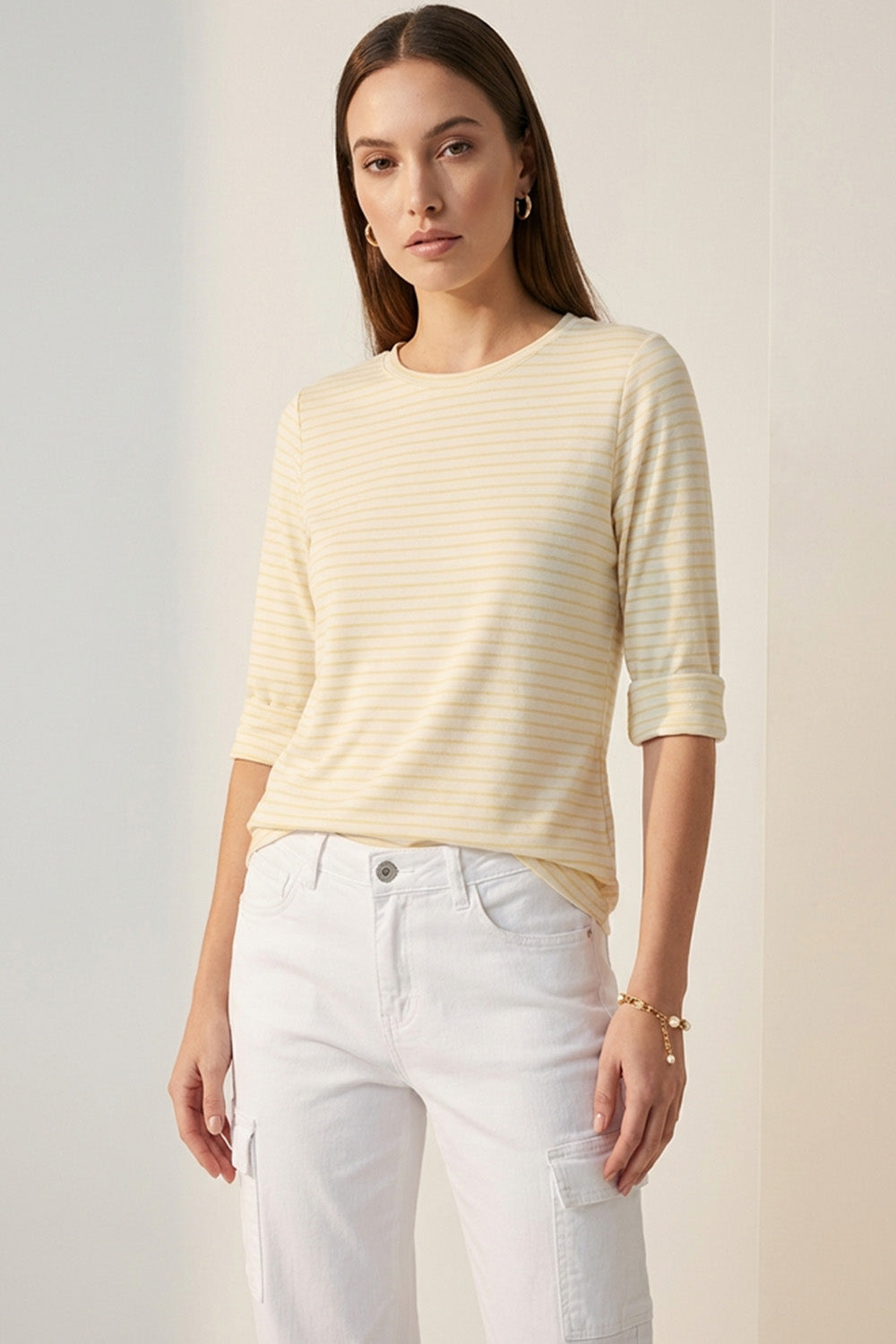 Κίτρινη ριγέ μπλούζα με 3/4 μανίκι και στρογγυλή λαιμόκοψη φορεμένη με λευκό παντελόνι