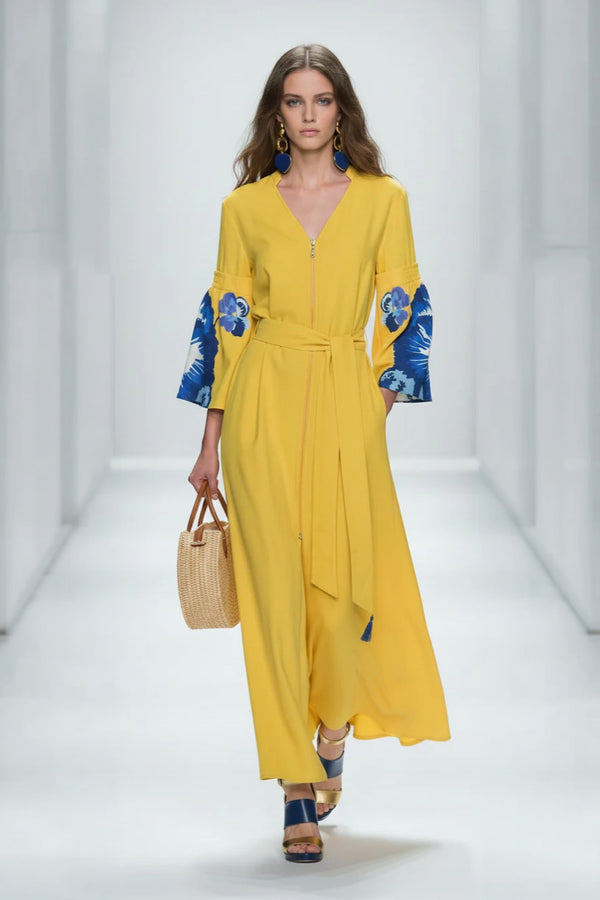 Κίτρινο μάξι φόρεμα με V λαιμόκοψη, floral μανίκια σε μπλε αποχρώσεις και ζώνη στη μέση.