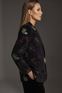 Γυναικείο κοτλέ σακάκι σε σκούρο χρώμα με floral λεπτομέρειες, σε κομψή γραμμή, φορεμένο από μοντέλο σε studio φωτογράφιση.
