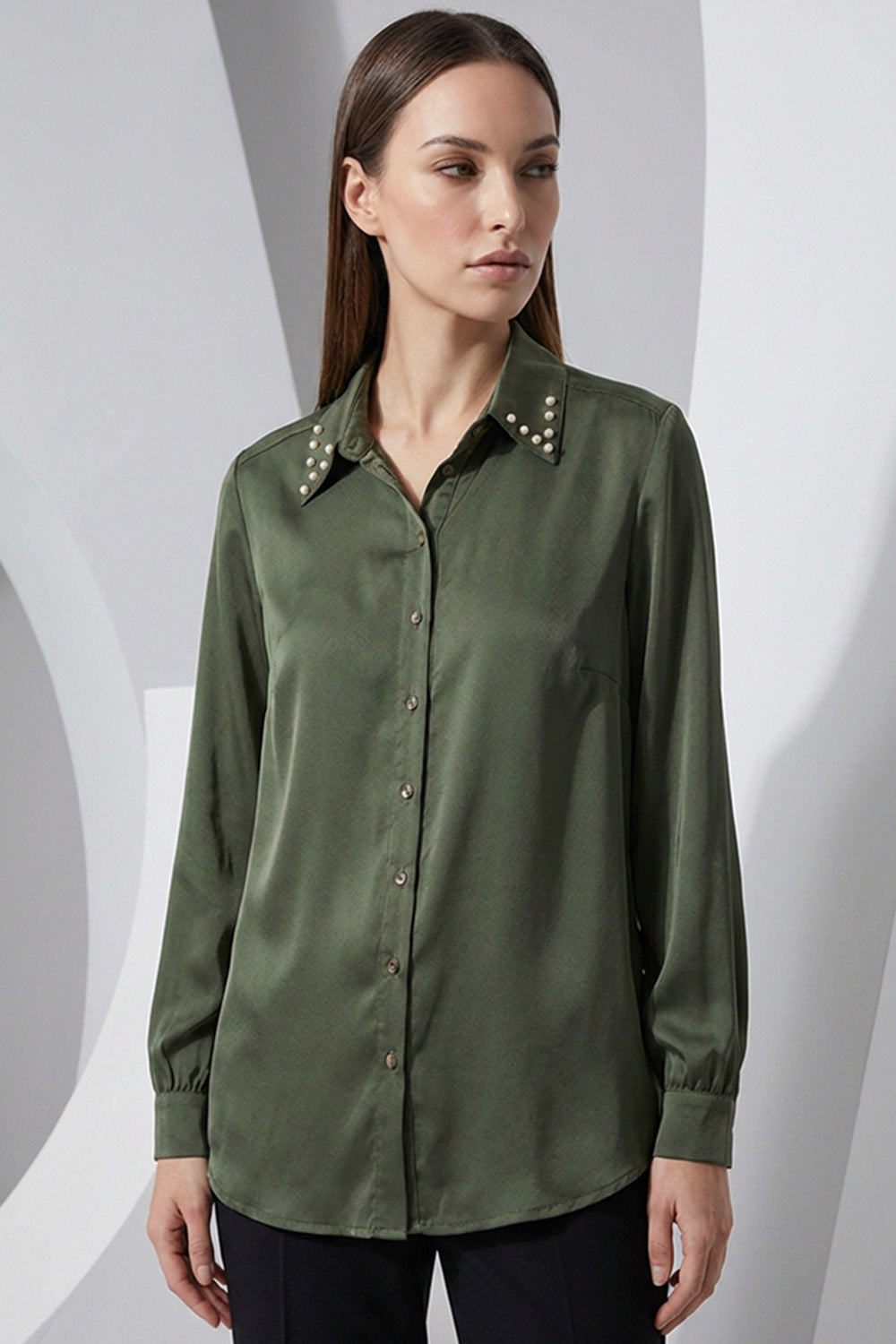 Λαδί γυναικείο πουκάμισο με μεταλλικά τρουκς στον γιακά και μακρύ μανίκι, σε άνετη γραμμή.