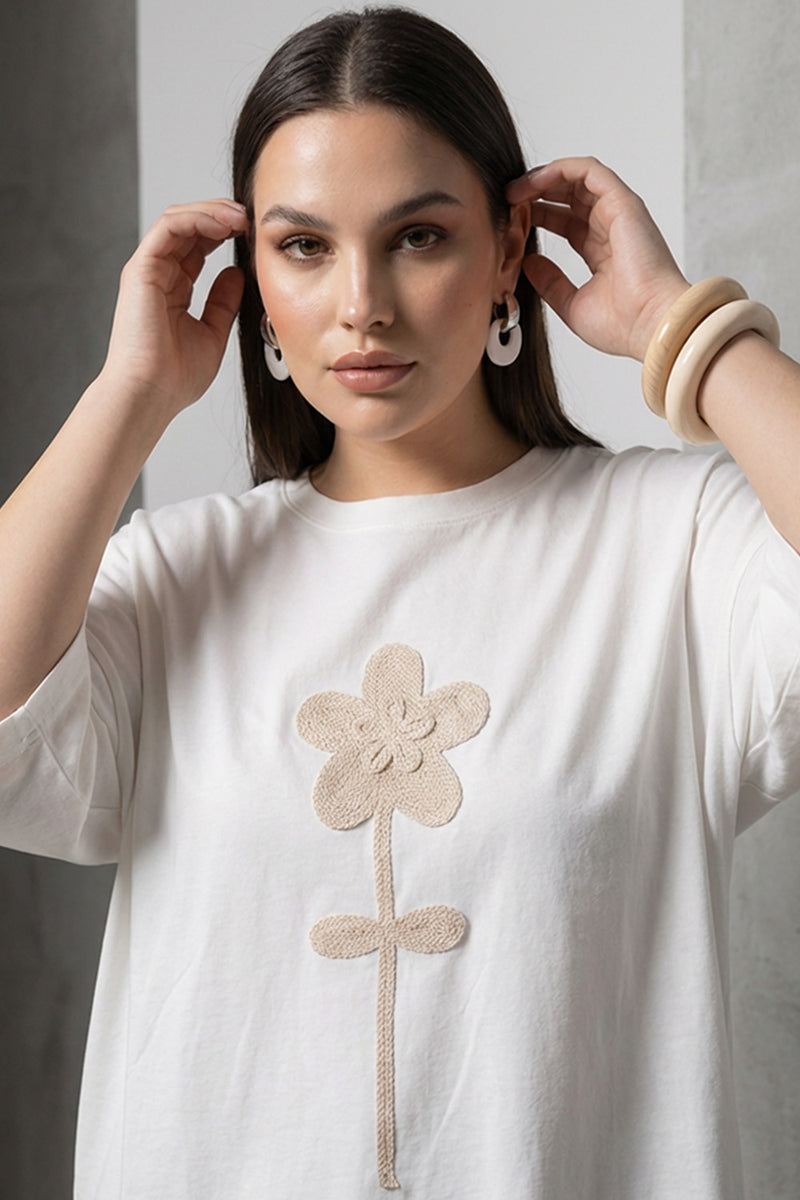 Λευκή oversized μπλούζα με μπεζ ανάγλυφο λουλούδι στο κέντρο και κοντά μανίκια.
