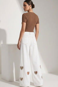 Λευκό γυναικείο τζιν παντελόνι με cut-out καρδιές και διακοσμητικά strass