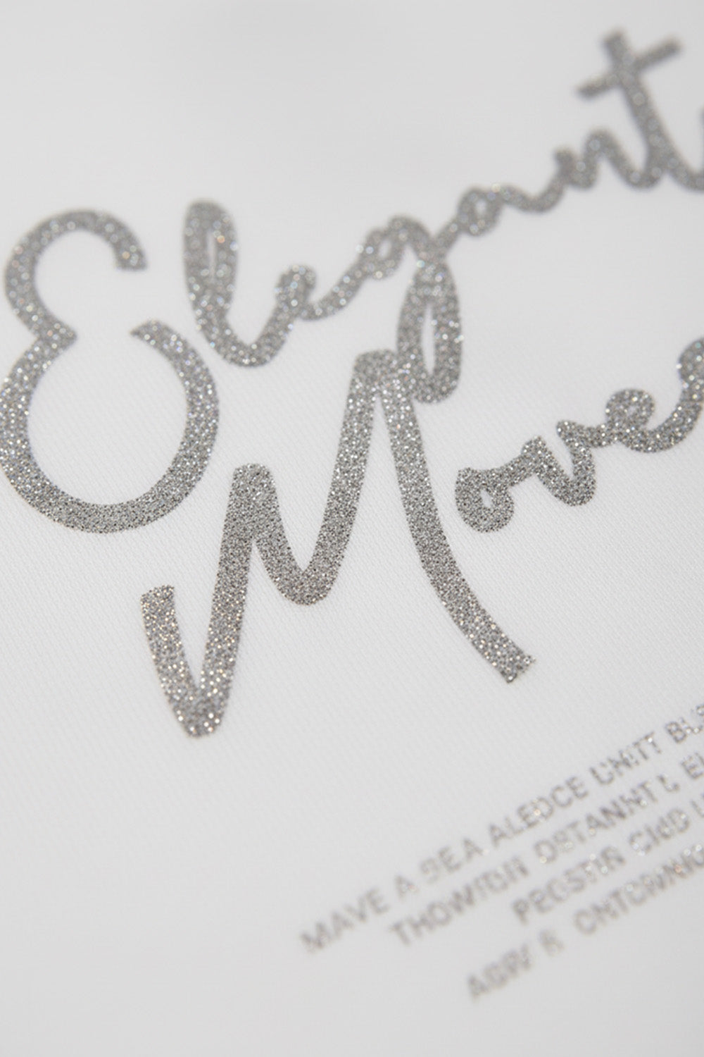 Λευκό γυναικείο T-shirt με ασημί μεταλλιζέ τύπωμα Elegant Moves στο μπροστινό μέρος