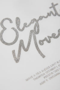 Λευκό γυναικείο T-shirt με ασημί μεταλλιζέ τύπωμα Elegant Moves στο μπροστινό μέρος