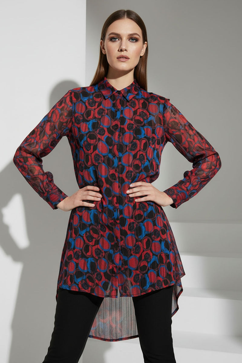 Μακρύ εμπριμέ πουκάμισο σε κόκκινο και μπλε με μακριά μανίκια και ασύμμετρο μήκος, φορεμένο από μοντέλο.