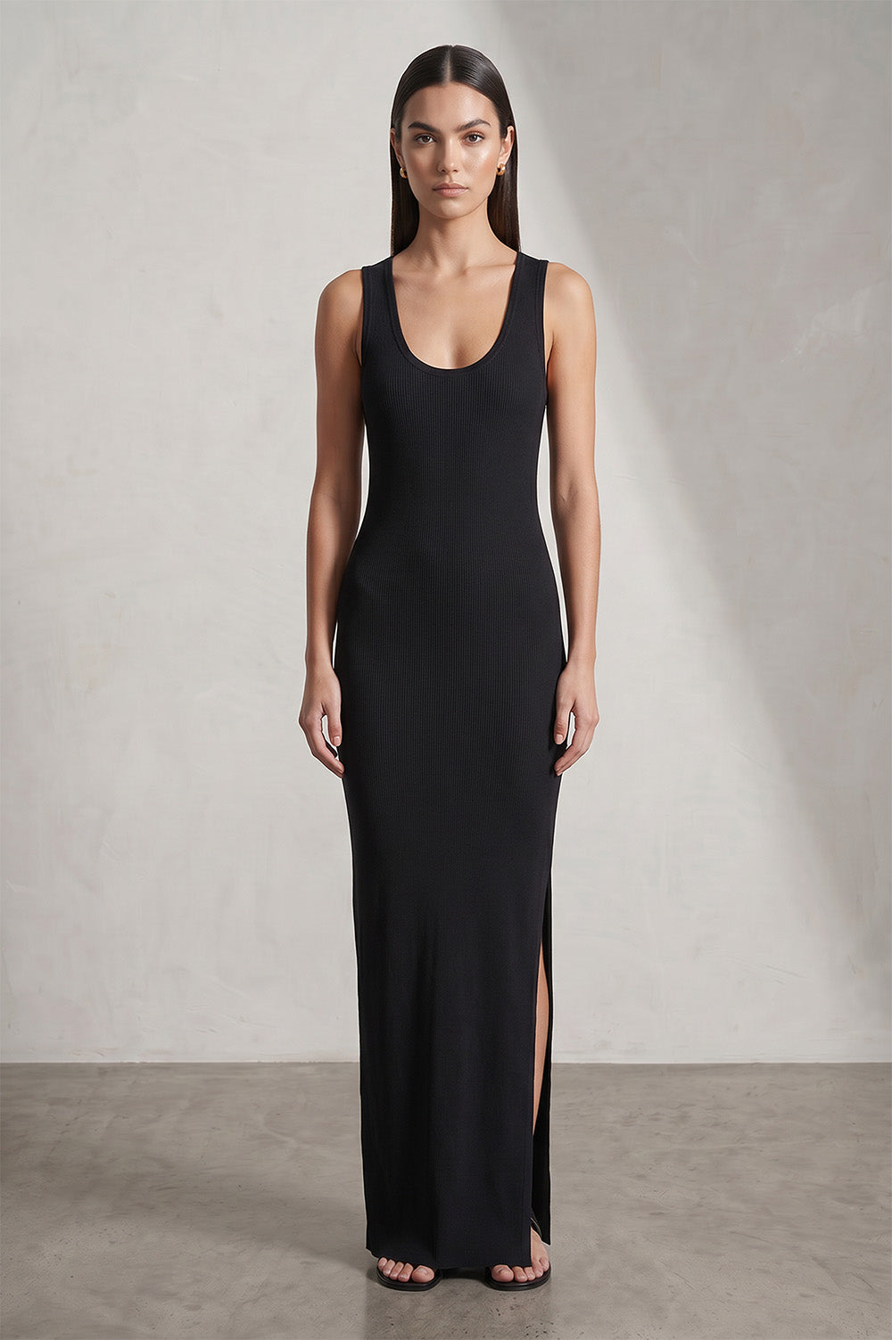 Μαύρο maxi rib γυναικείο φόρεμα, αμάνικο, με στρογγυλή λαιμόκοψη, πλαϊνό άνοιγμα και χρυσό κέντημα στην πλάτη.