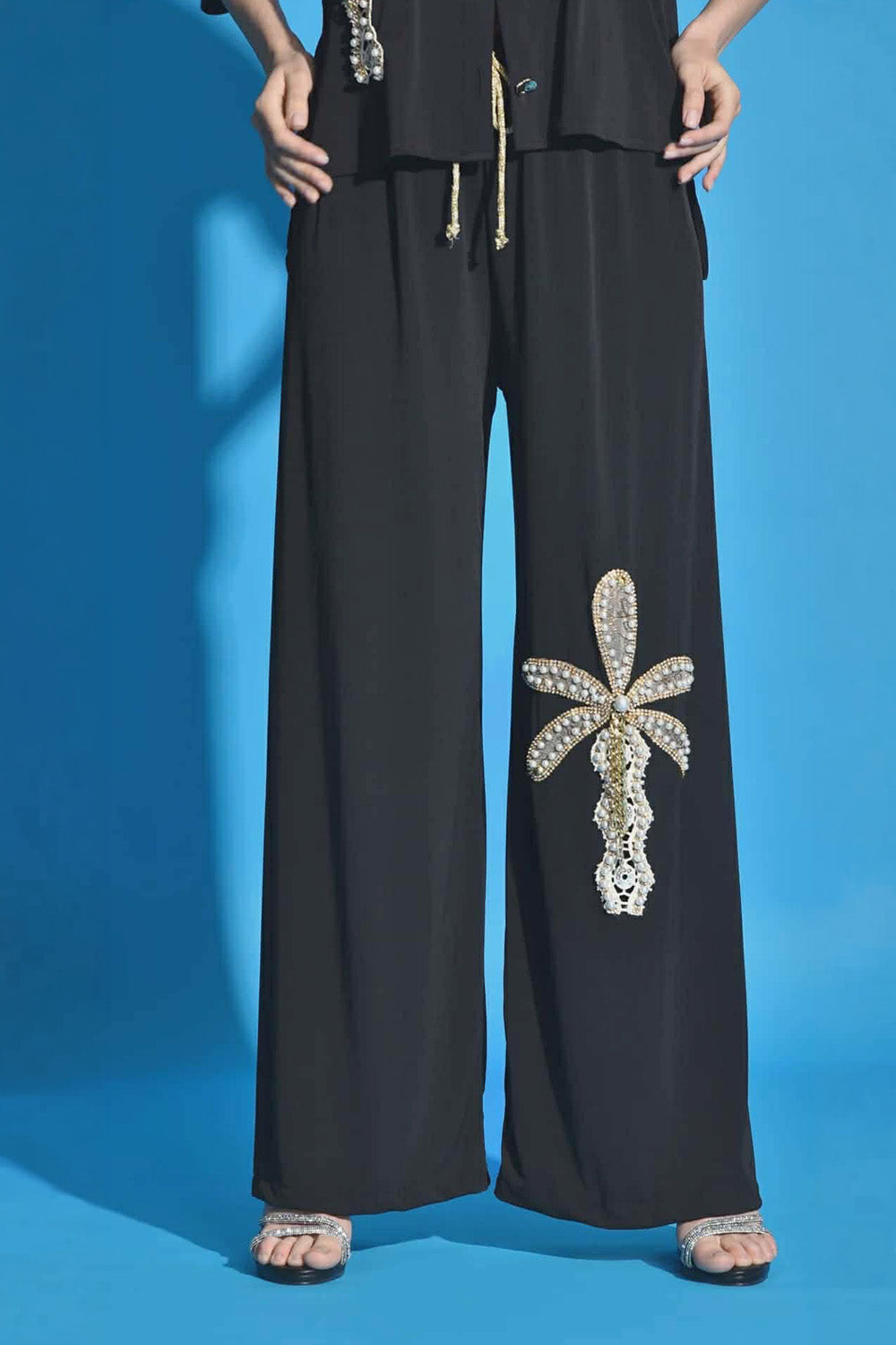 Λεπτομέρεια λιβελούλας με πέρλες σε μαύρο παντελόνι
