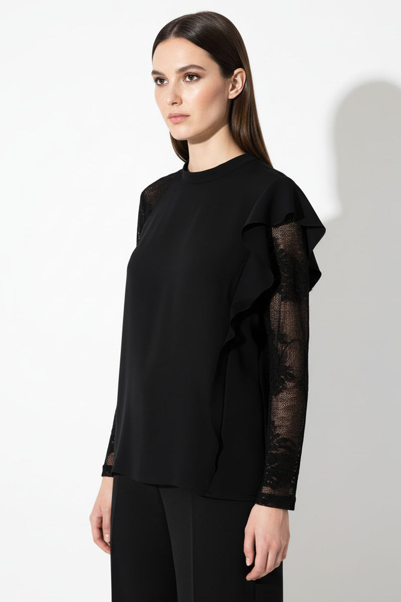Μαύρη μπλούζα με δαντέλα στα μανίκια και βολάν στον έναν ώμο, κομψή εφαρμογή, φωτογραφία μοντέλου.