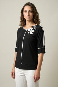 Μαύρη γυναικεία μπλούζα με λευκές γραμμικές ραφές και τρισδιάστατα λουλούδια στον ώμο