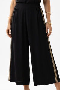 Μαύρη Crop Παντελόνα με Πλαϊνή Τρέσα σε μαύρο χρώμα με χρυσές λεπτομέρειες.