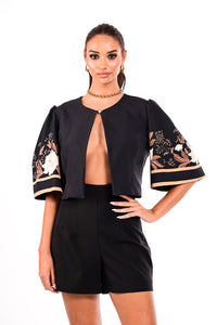 Μαύρο crop σακάκι με floral λεπτομέρειες στα μανίκια, φορεμένο από μοντέλο σε total black σύνολο.