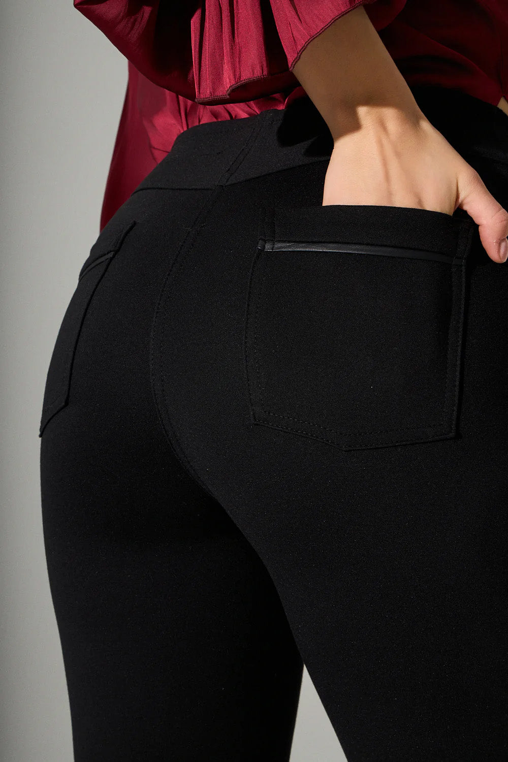 Μαύρο γυναικείο παντελόνι καμπάνα με ψηλόμεση γραμμή και πίσω τσέπες, φορεμένο σε μοντέλο σε studio περιβάλλον