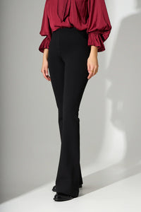 Μαύρο γυναικείο παντελόνι καμπάνα με ψηλόμεση γραμμή και πίσω τσέπες, φορεμένο σε μοντέλο σε studio περιβάλλον