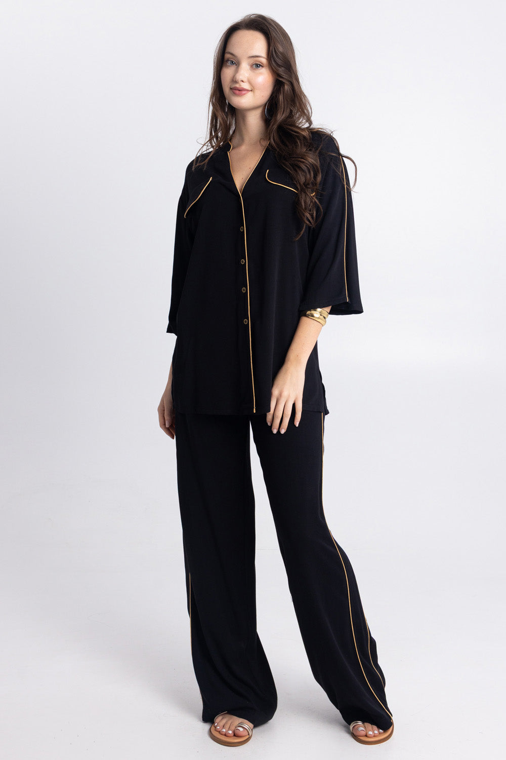 Μαύρο σετ με πουκάμισο και παντελόνα με χρυσές λεπτομέρειες.
