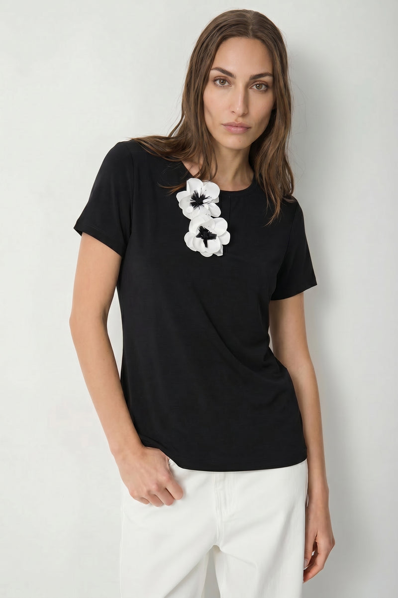 Γυναικείο μαύρο T-shirt με λευκά τρισδιάστατα λουλούδια στο μπροστινό μέρος και κοντά μανίκια.