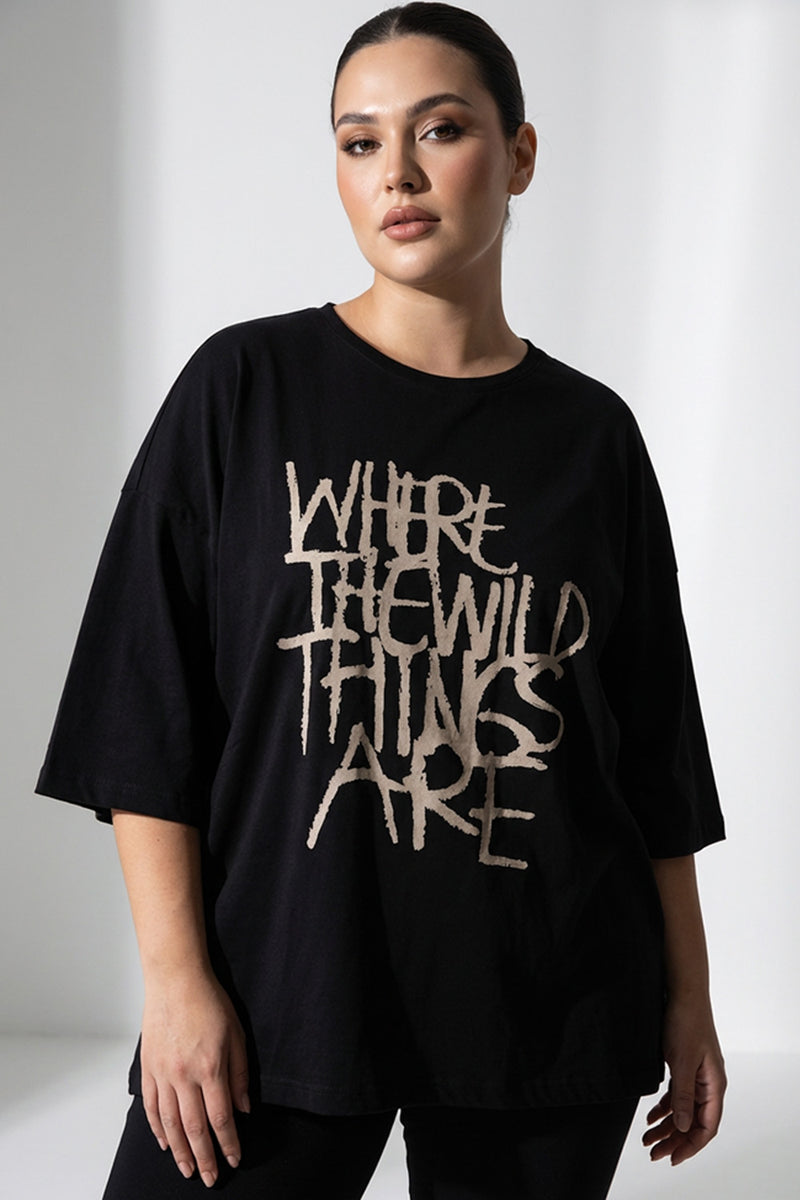 Μαύρο γυναικείο T-shirt με τύπωμα “Where the Wild Things Are” σε άνετη γραμμή, φορεμένο από μοντέλο.