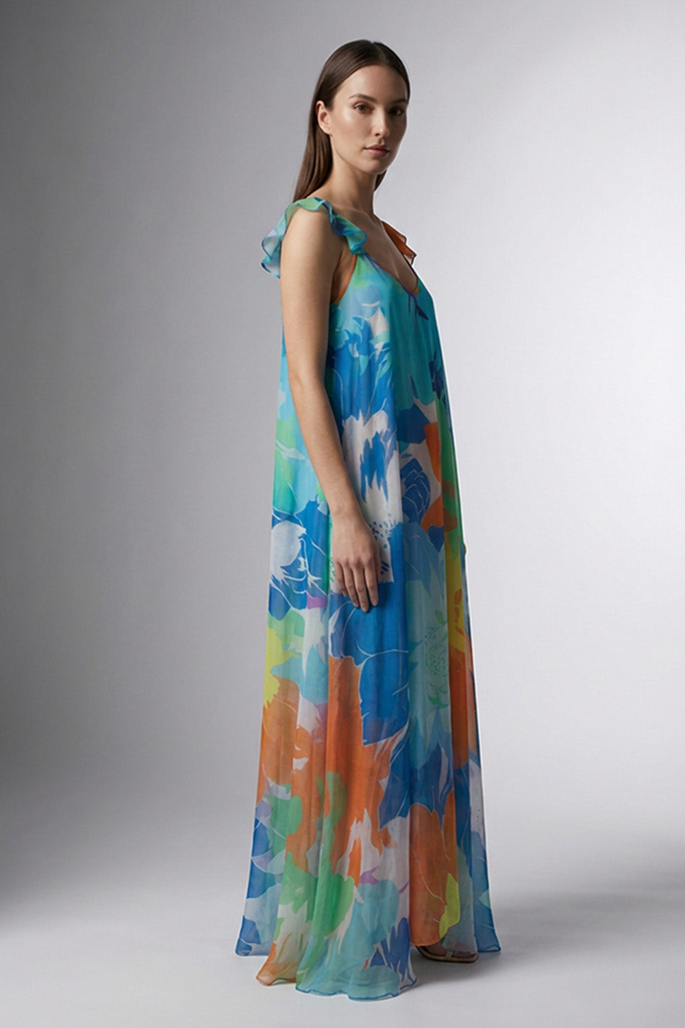 Μάξι εμπριμέ σιφόν φόρεμα με V λαιμόκοψη, λεπτές τιράντες με βολάν και αέρινη γραμμή σε μπλε και πολύχρωμους τόνους.