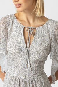 Γυναικείο maxi φόρεμα εκρού με μικρό print, δέσιμο στο λαιμό και βολάν στο τελείωμα