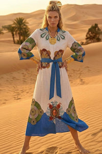 Maxi σεμιζιέ φόρεμα σε λευκή βάση με πολύχρωμο boho print, μανίκια 3/4 και αποσπώμενη μπλε ζώνη.