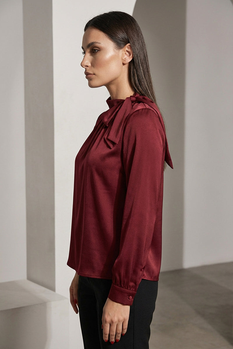 Μπορντό μπλούζα με δέσιμο στο λαιμό και μακρύ μανίκι, κομψή γραμμή, φορεμένη από μοντέλο σε minimal studio φόντο