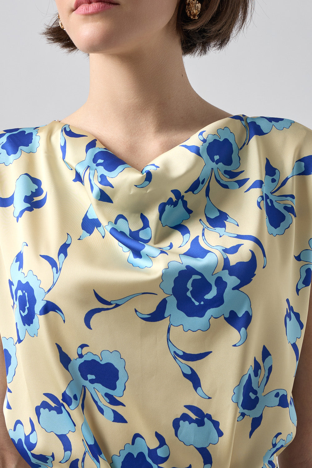 Γυναικεία μπεζ μπλούζα με μπλε φλοράλ σχέδιο, ντραπέ λαιμόκοψη και ζωνάκι στη μέση