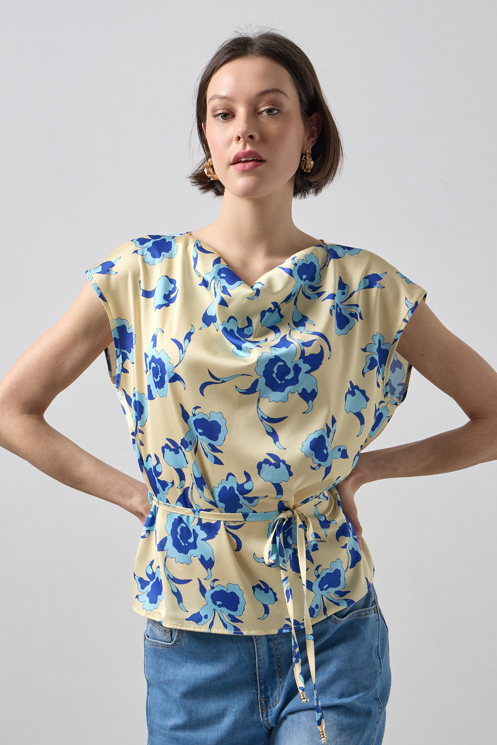 Γυναικεία μπεζ μπλούζα με μπλε φλοράλ σχέδιο, ντραπέ λαιμόκοψη και ζωνάκι στη μέση