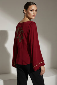 Κόκκινη μπλούζα iRous με φαρδιά μανίκια και χρυσοκεντημένο σχέδιο στην πλάτη, φωτογράφιση στούντιο.