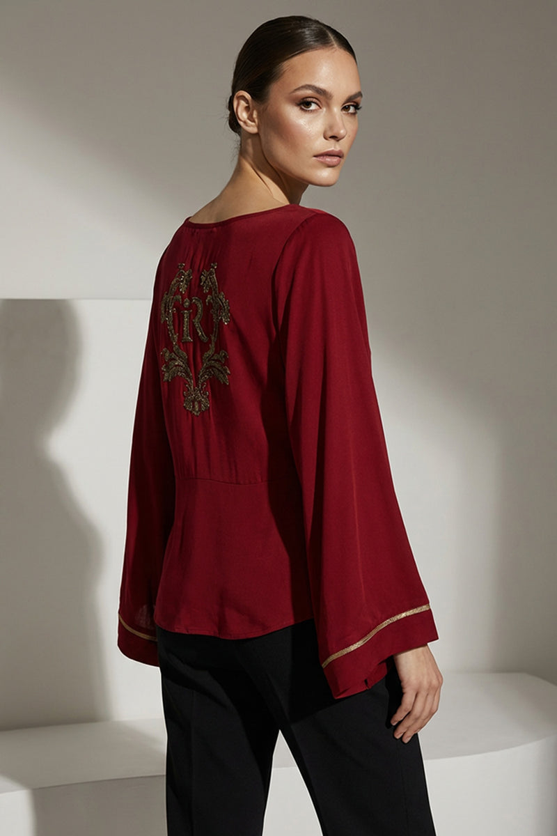 Κόκκινη μπλούζα iRous με φαρδιά μανίκια και χρυσοκεντημένο σχέδιο στην πλάτη, φωτογράφιση στούντιο.