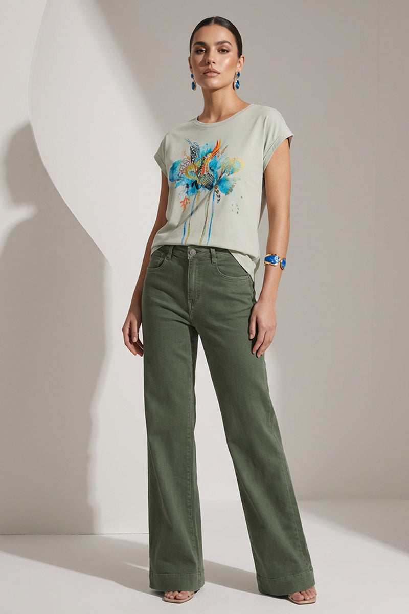 Γυναικεία φυστικί μπλούζα με καλλιτεχνικό τύπωμα σε μπλε και ώχρα αποχρώσεις, φορεμένη με χακί παντελόνι.