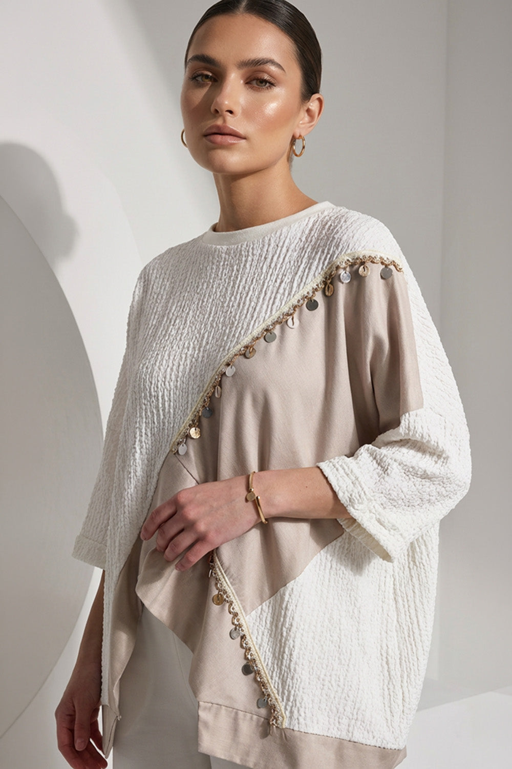 Εκρού γυναικεία μπλούζα με μπεζ ασύμμετρη λεπτομέρεια και διακοσμητική τρέσα με μεταλλικά στοιχεία