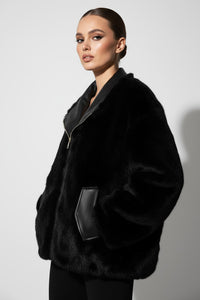Μαύρο μπουφάν διπλής όψεως, με μία πλευρά γούνα και μία δερματίνη, σε oversized γραμμή.