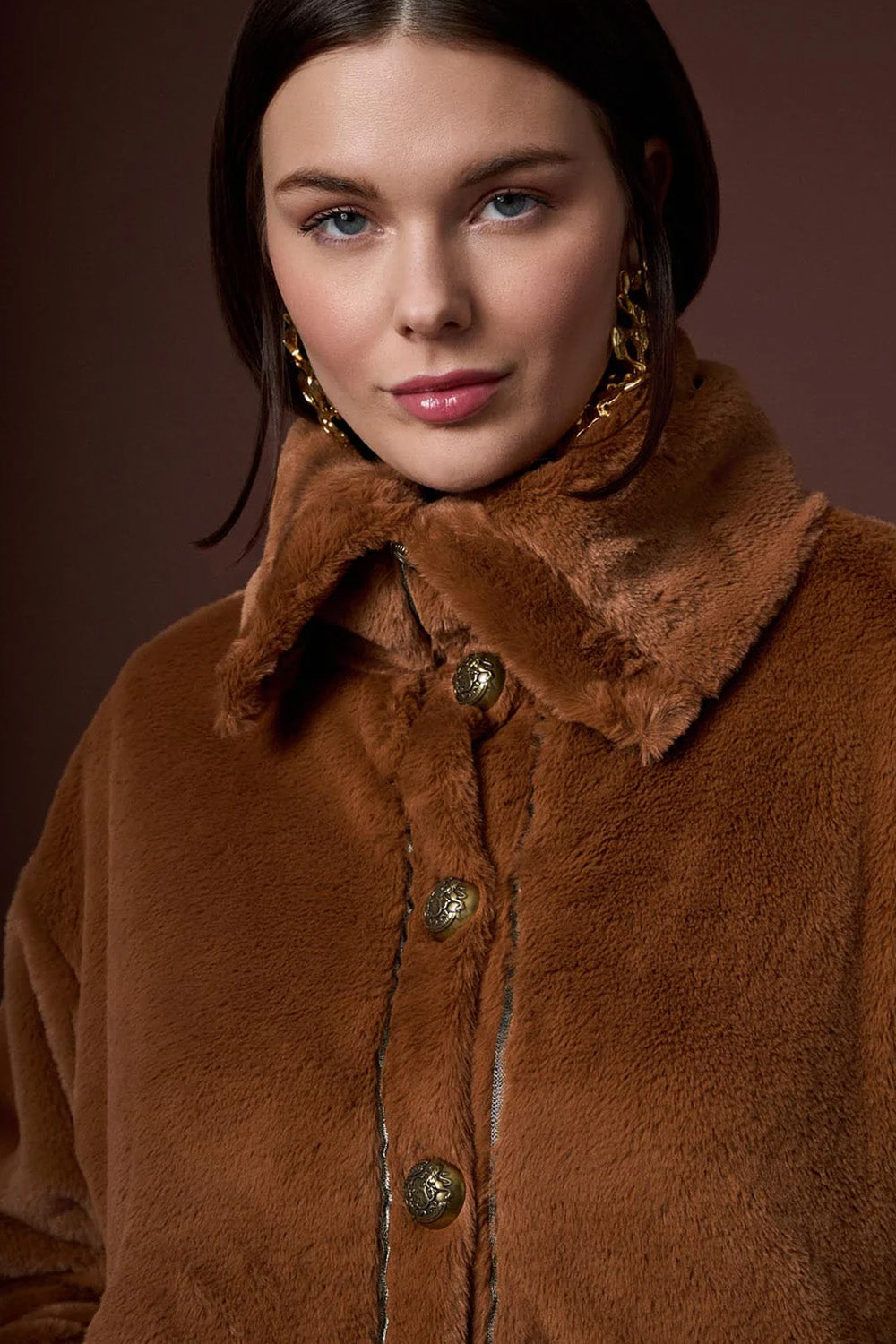 Καφέ γούνινο μπουφάν iRous με χρυσά κουμπιά και κεντημένο μοτίβο στην πλάτη, φωτογράφιση στούντιο.