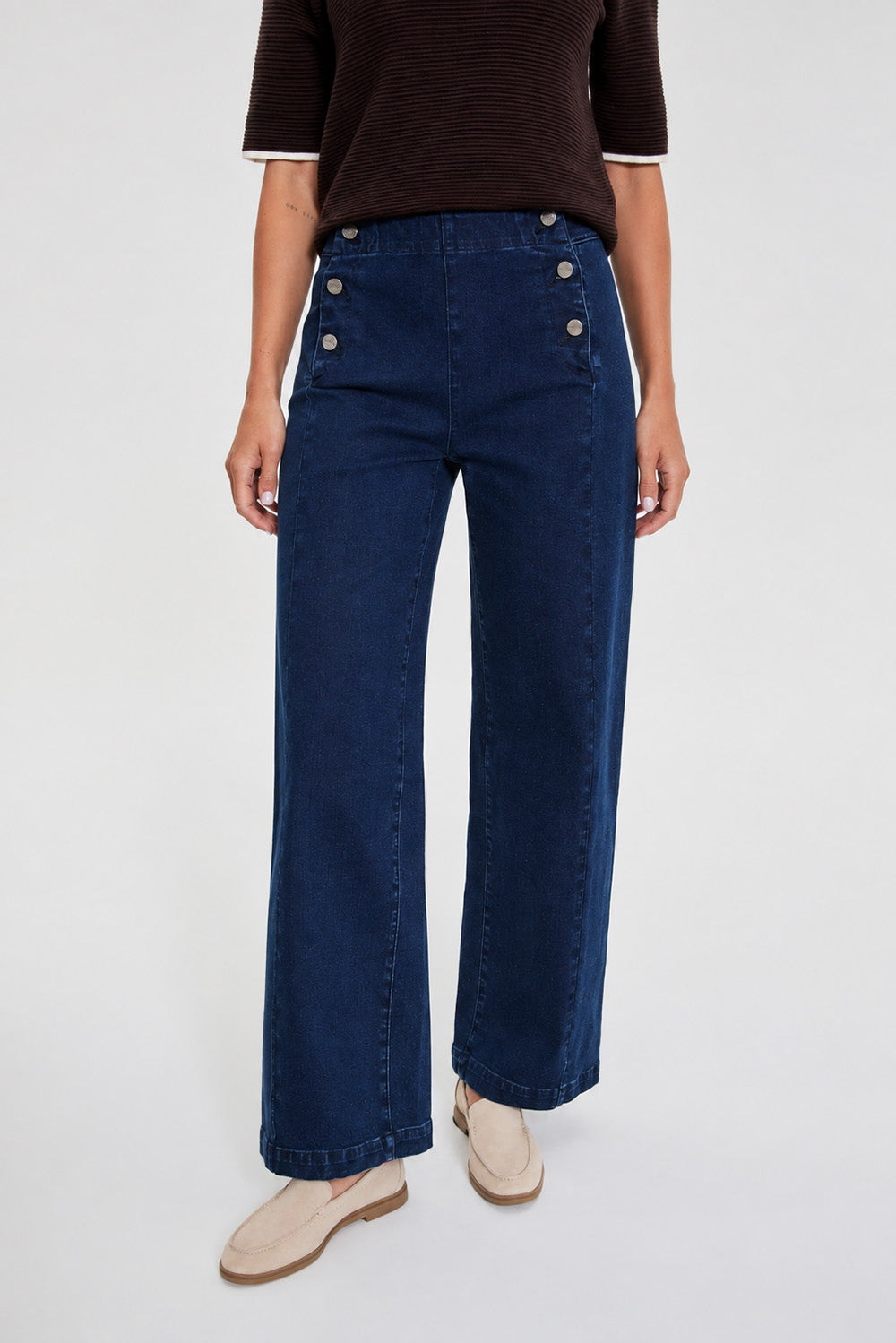 Λεπτομέρεια μπλε denim παντελονιού με διακοσμητικά μεταλλικά κουμπιά