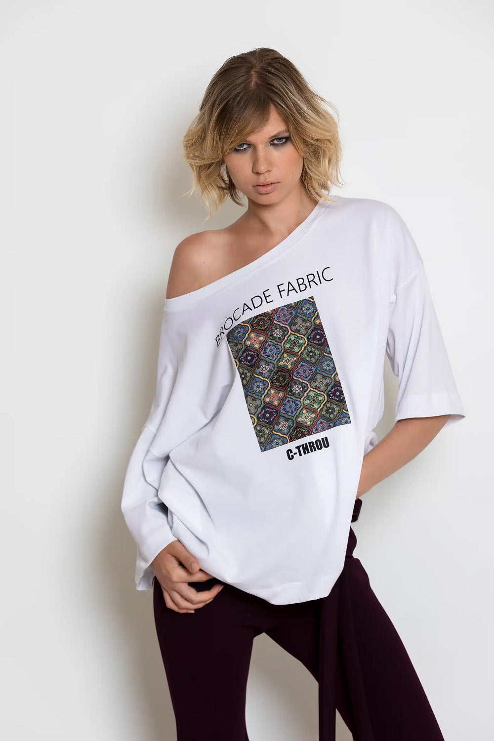 Λευκό oversized T-shirt C-THROU με φαρδιά λαιμόκοψη, ασύμμετρα μανίκια και πολύχρωμη στάμπα.
